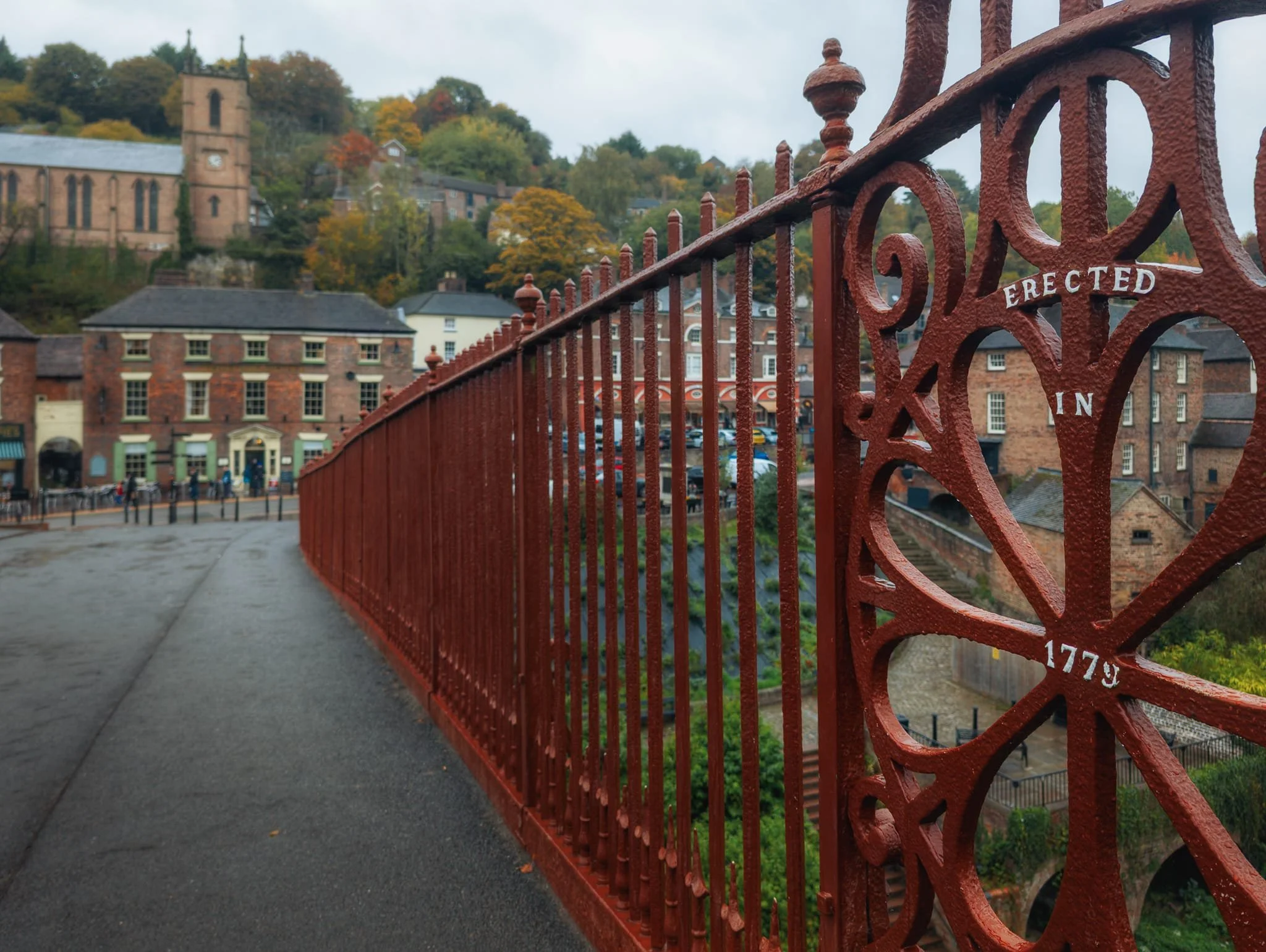  On the bridge I tried to feature the beautiful wrought iron work on the bridge, using the railing as a leading line towards the village. It&rsquo;s had some restoration work done over the centuries, of course, with the most recent in 2018 that also restored the original red colour of the bridge. 
