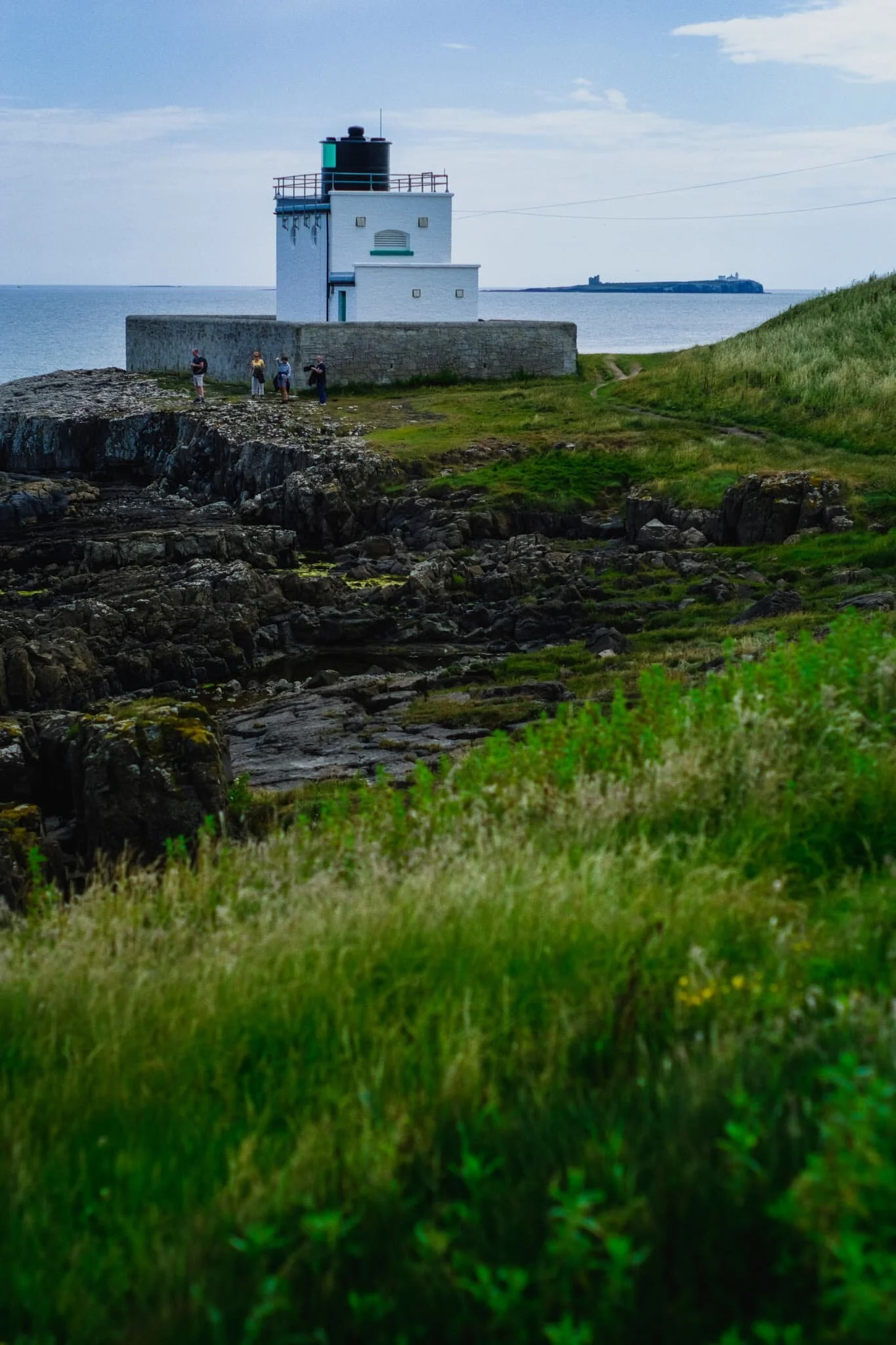  Heading back south towards Bamburgh, the day brightened up and people had arrived to soak up the sun. In the distance, you can make out one of the Farne Islands, an important wildlife habitat. 