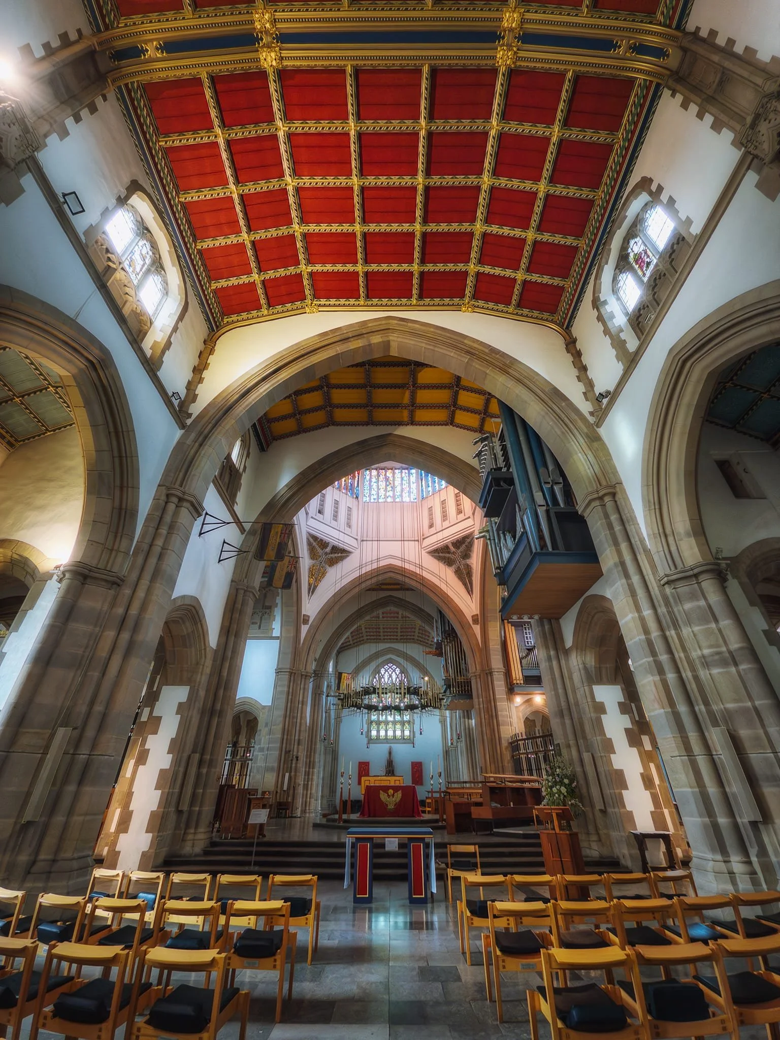  The transept and sanctuary, with the base of the lantern tower&rsquo;s colourful glass just visible. 