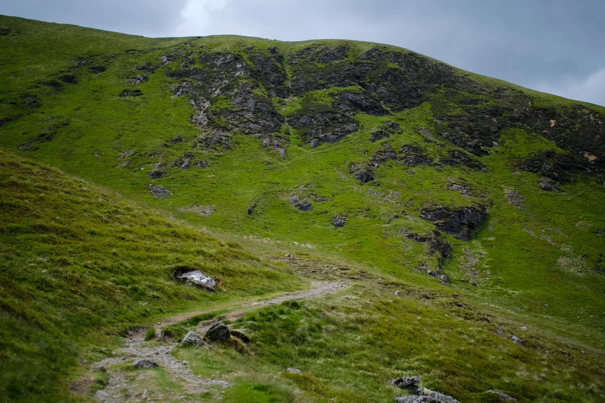 Bowscale Tarn is near. The bridleway skirts around this moraine &ldquo;lip&rdquo; that keeps the water where it is. Ahead is the wall known sensibly as Tarn Crags. 