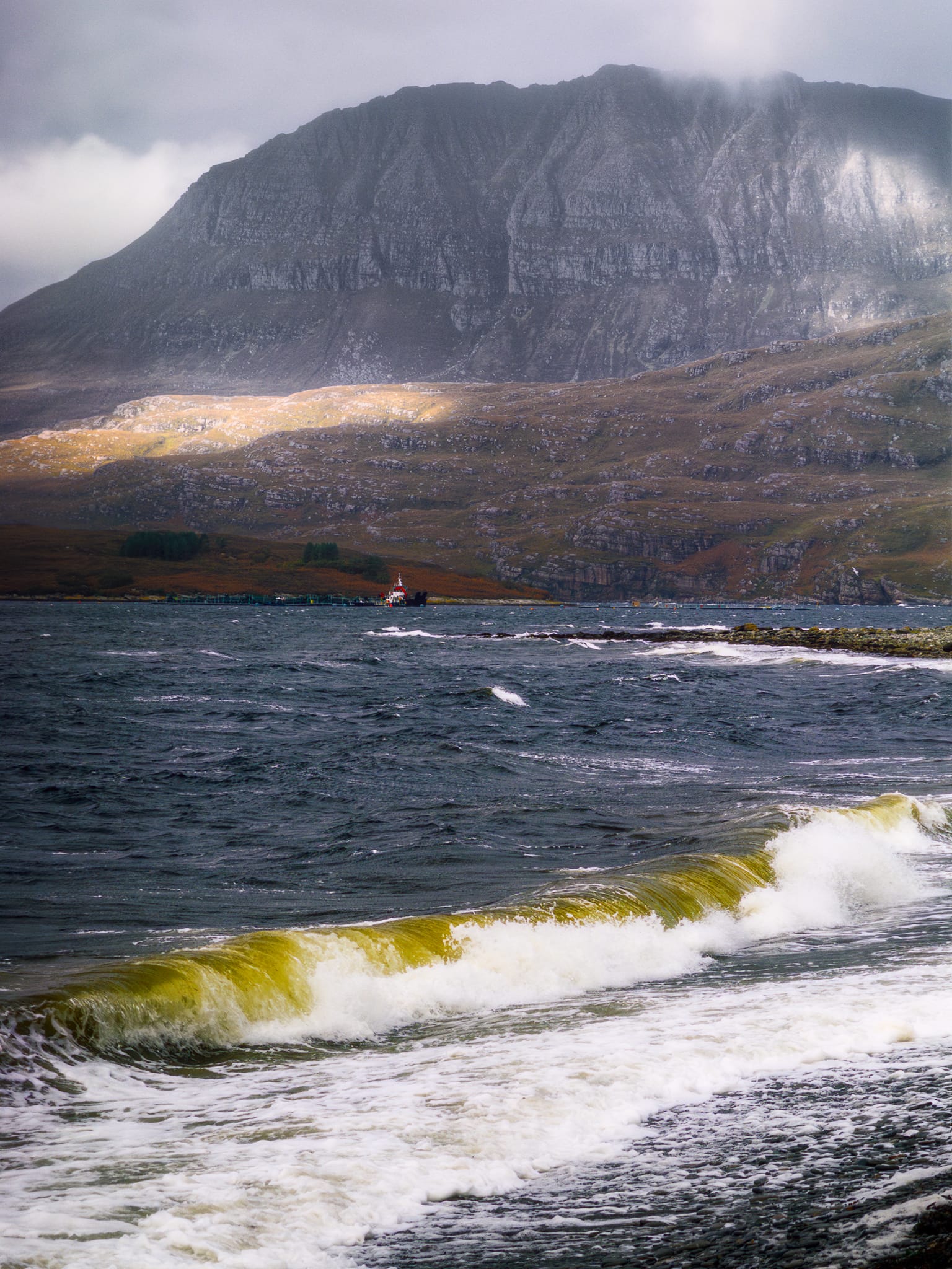 On the way to the Inverpolly area, north of Ullapool, there’s a small bit of coastline called Ardmair and it offers a stonking taster of what’s to come. Across Loch Canaird, Ben Mor Coigach (743 m/2,438 ft) presents as a sheer wall rising straight out of the sea. We stopped for photos as we battled the powerful gusts in the storm.
