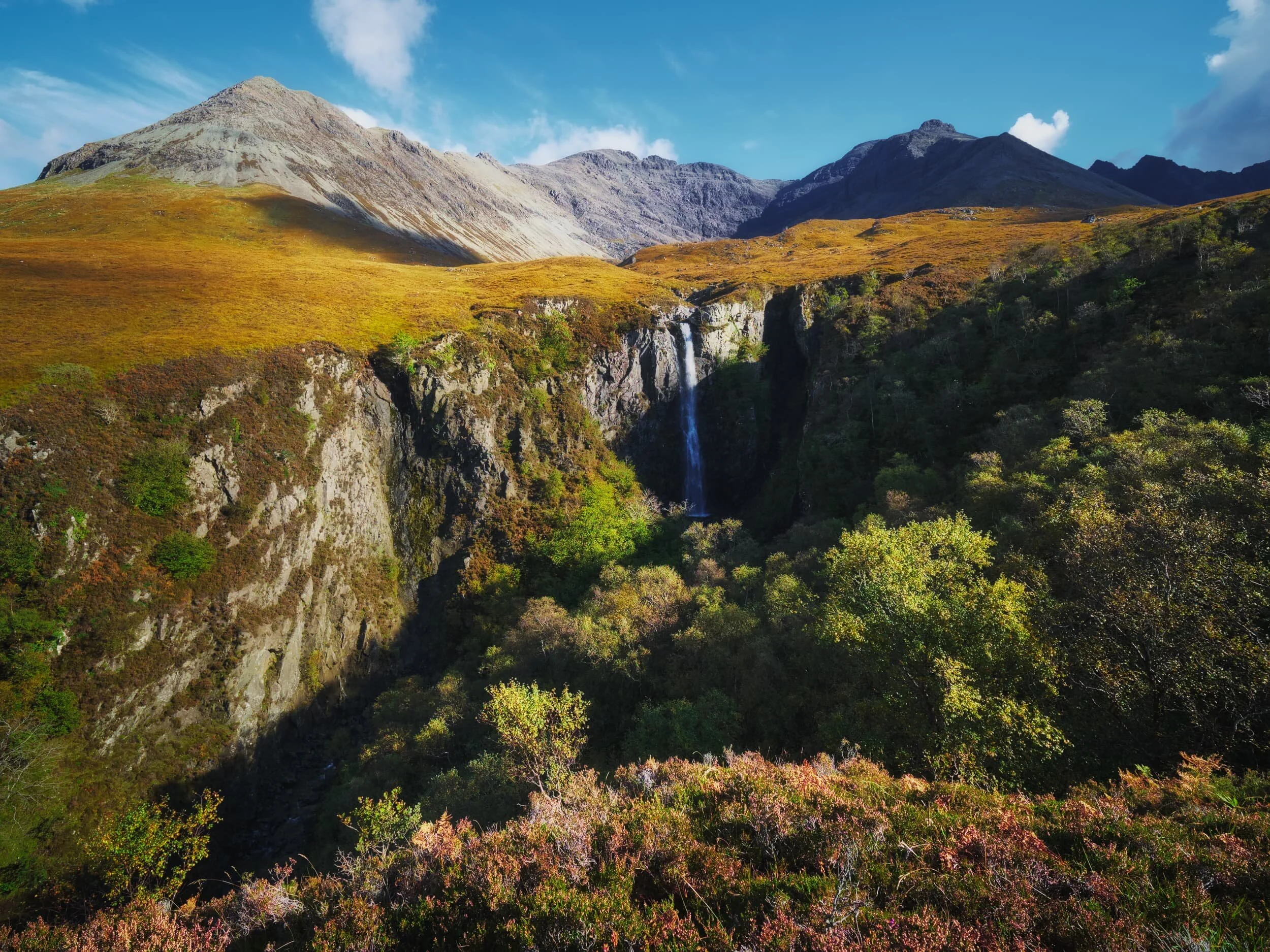  Further down Glen Brittle, towards its terminus as it pours out into Loch Brittle, you can hike up alongside less-visited rivers and their own waterfalls. Near the Glen Brittle Youth Hostel we park for a hike up the river  Allt Coire Banachdich , as it pours down from the western flanks of the Black Cuillins. 300+ ft up the river this view suddenly opens up, revealing a deep and sheer gorge that the river has carved, now dropping 150+ ft as the waterfall known as  Eas Mòr . A truly awe-inspiring site, especially with the western Black Cuillins above. 