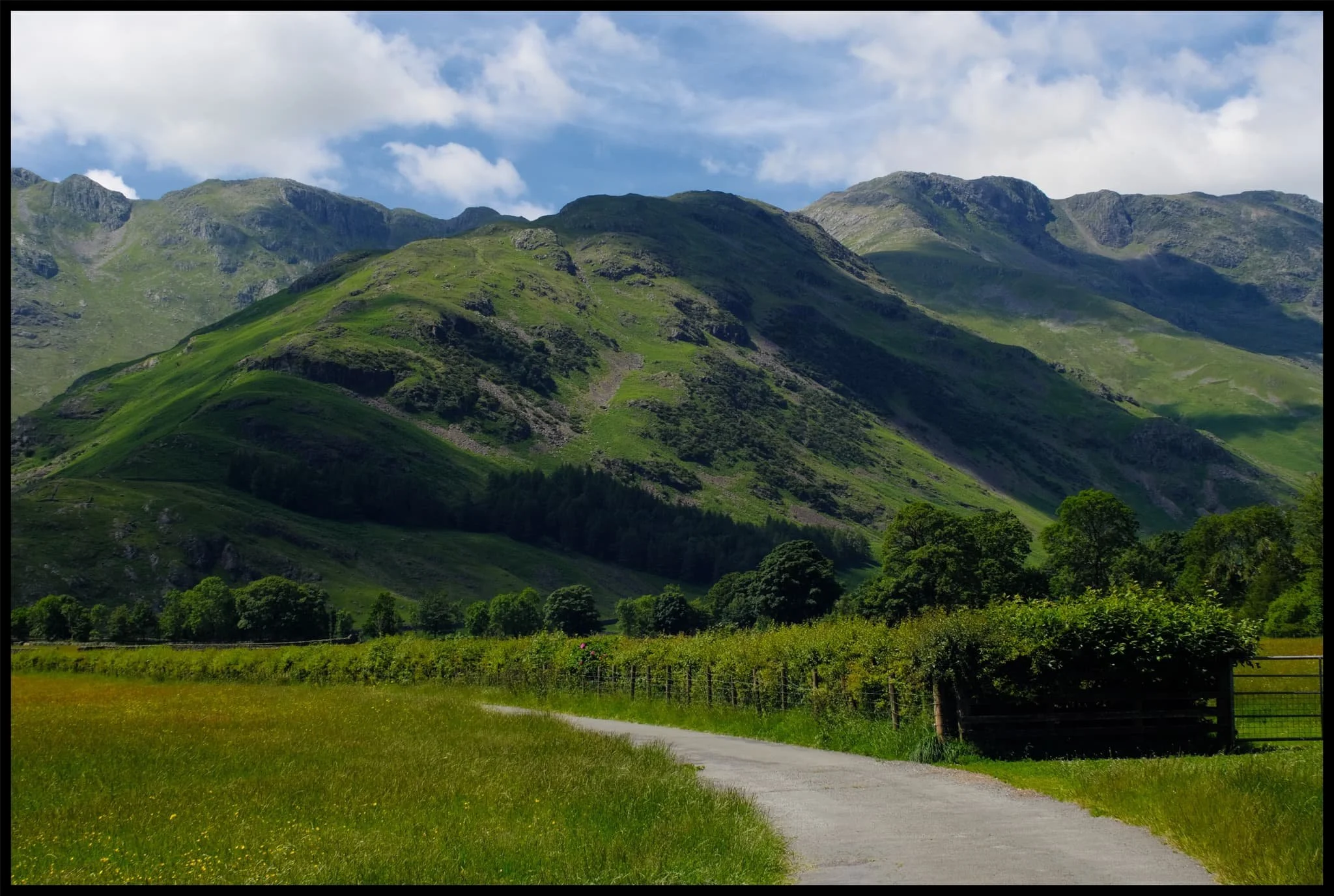  The western aspect of Great Langdale features its highest fells, accessible via the fell in the middle of this photo known as &ldquo;The Band&rdquo;. To the left is Crinkle Crags (859 m/2,818 ft) and to the right is Bowfell (902 m/2,959 ft). 