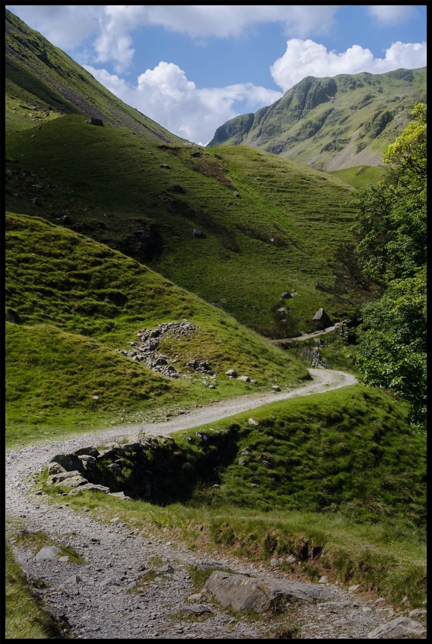  The trail narrows and winds as we approach the head of Grisedale. High above us are Falcon Crag and Tarn Crag, which drop down to Grisedale Tarn. 