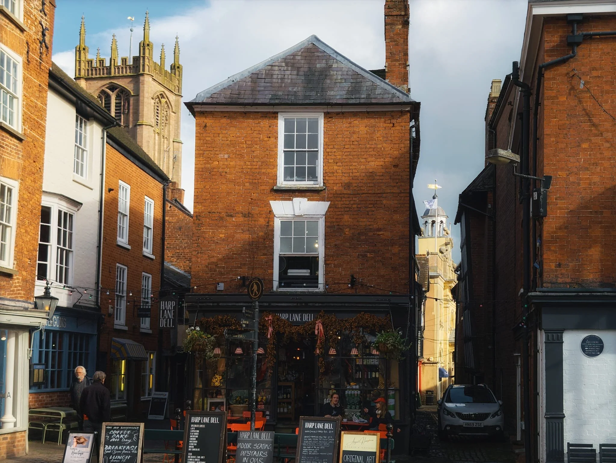  From the Market Square near Ludlow Castle, a view looking back to Ludlow&rsquo;s wonky buldings, with St. Laurence&rsquo;s Church and the Butter Cross both draped in golden autumnal light. 