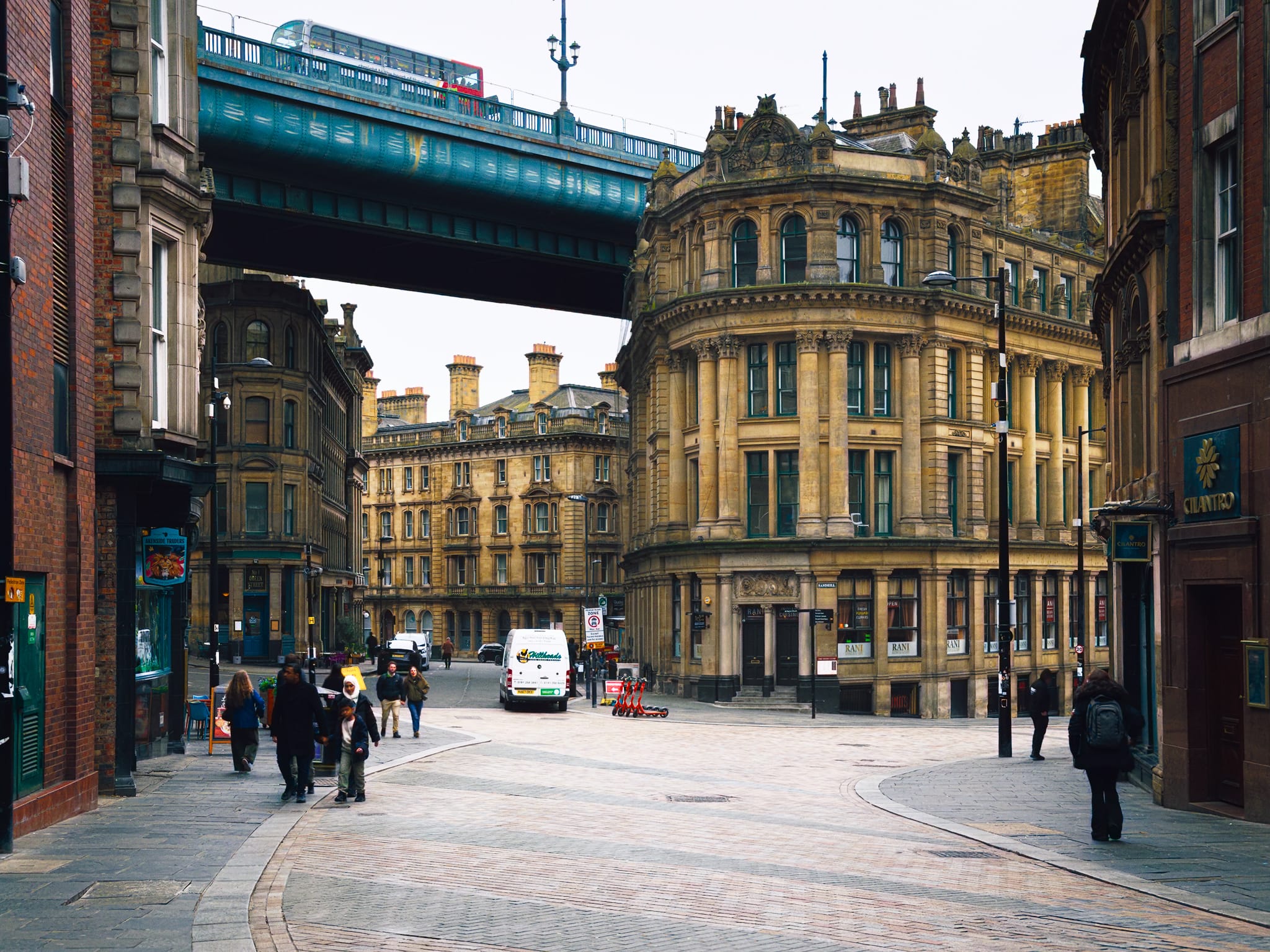 This image attracts and intrigues me. It puts me in mind of Dieselpunk or Steampunk vibes, y&rsquo;know? This is the view heading down Quayside, showing off the Phoenix House — a Grade II listed building constructed in 1869 for the Royal Insurance Company — and the Tyne Bridge that fits snugly overhead.