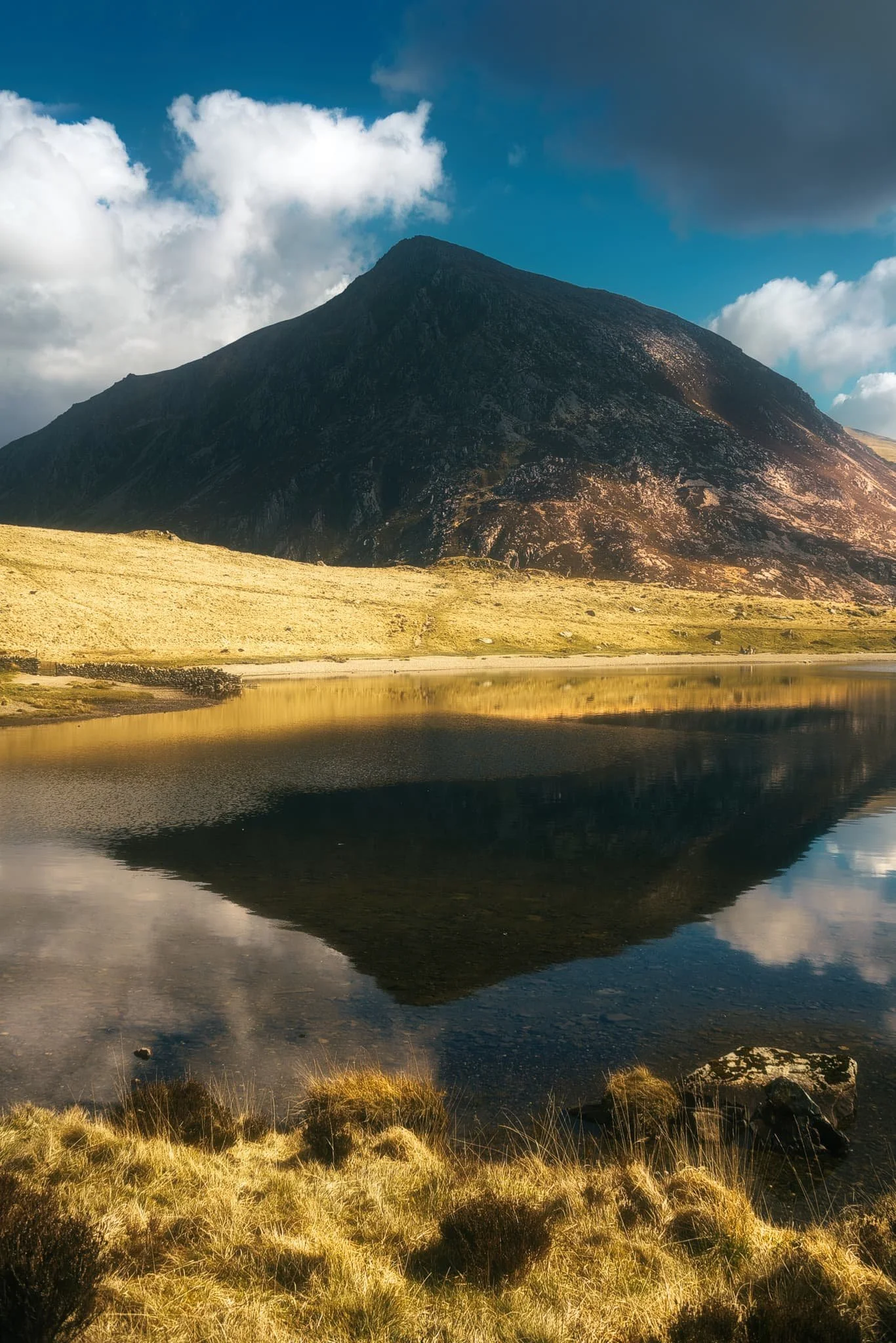  Nearly at the start of the Llyn Idwal circuit, the tarn is calm and flat enough to give a lovely reflection of Wales&rsquo; 7th highest mountain. 