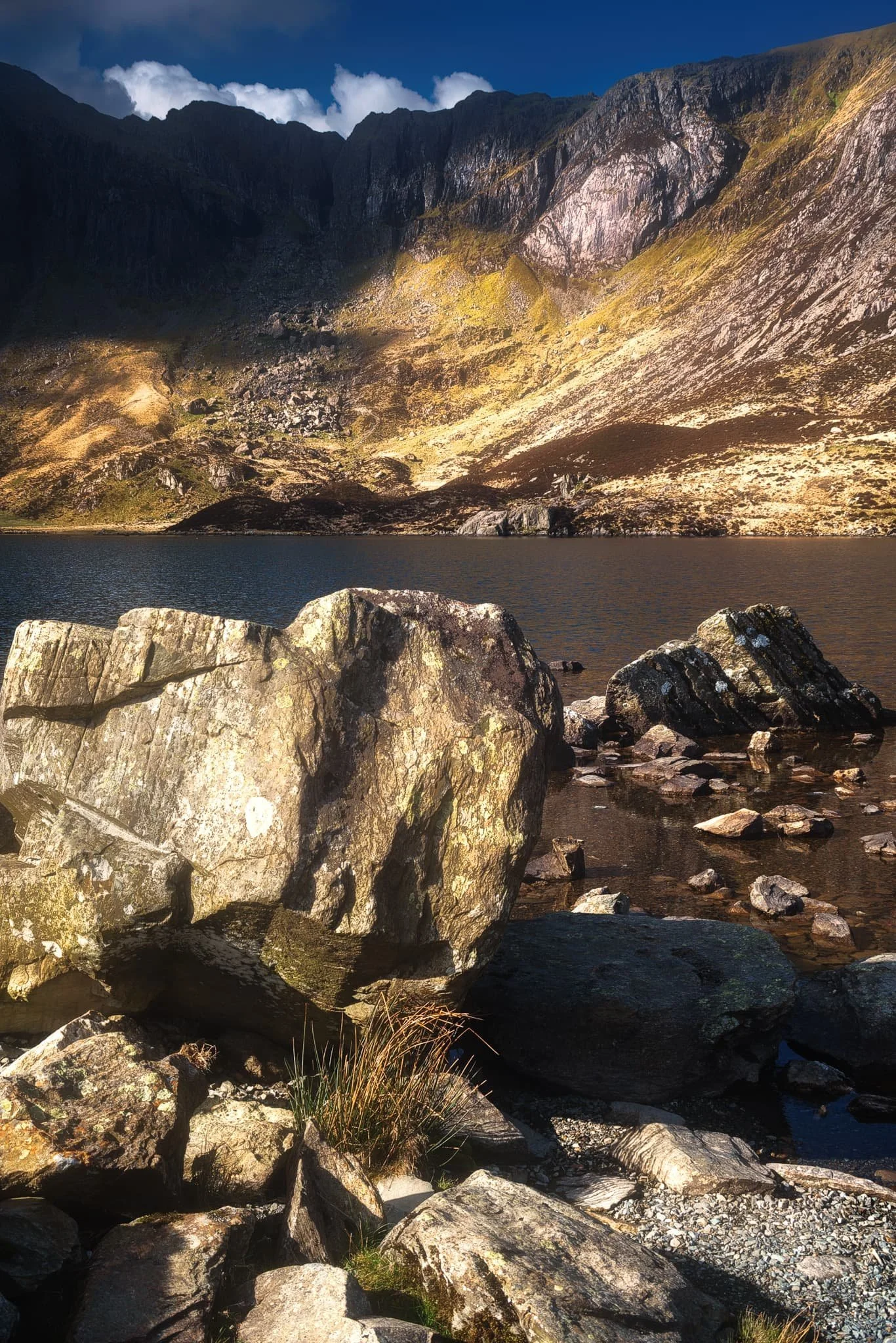  As we pottered about the shore of Llyn Idwal seeking out more compositions, what I hoped for finally happened. The Idwal Slabs, those towering cliffs of crag, starting catching the light. So I lined up this composition. 