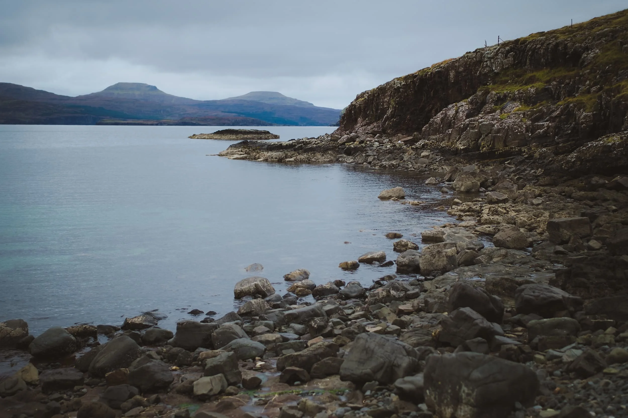  This is the shallow gravel bank that connects Ullinish Point to Oronsay at low tide. Beyond are the unmistakeable shapes of MacLeod&rsquo;s Tables; a pair of flat-topped hills that are characteristic features of the Duirinish peninsula of Skye. 
