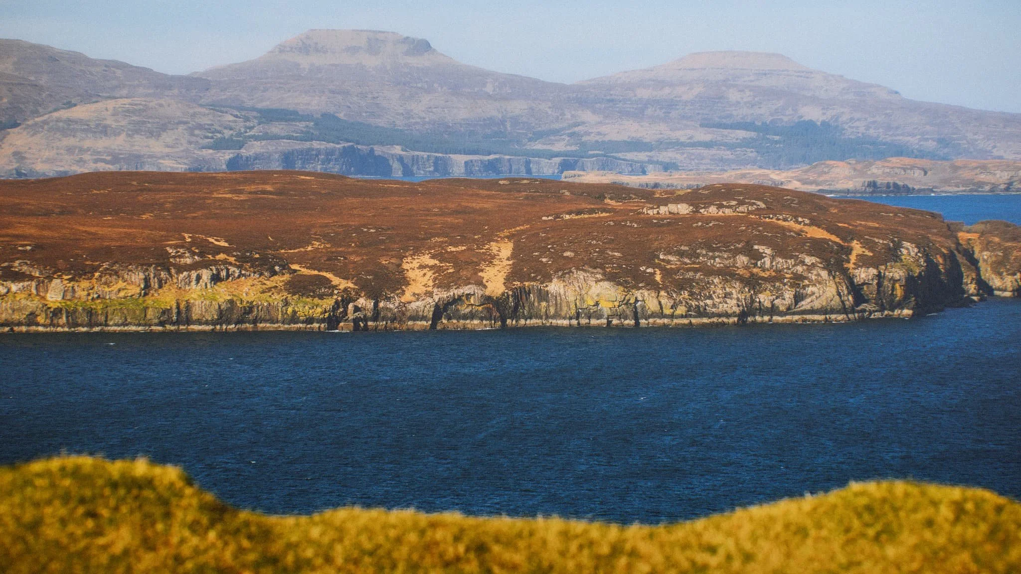  Looking further east, the eastern end of Wiay gives way to the two distinctive flat-topped hills on the  Duirinish  peninsula, known as MacLeod&rsquo;s Tables. The one on the left―MacLeod&rsquo;s Table South or  Healabhal Bheag ―is 489 m/1,604 ft. The one on the right―MacLeod&rsquo;s Table North or  Healabhal Mhòr ―is 469 m/1,538 ft. 