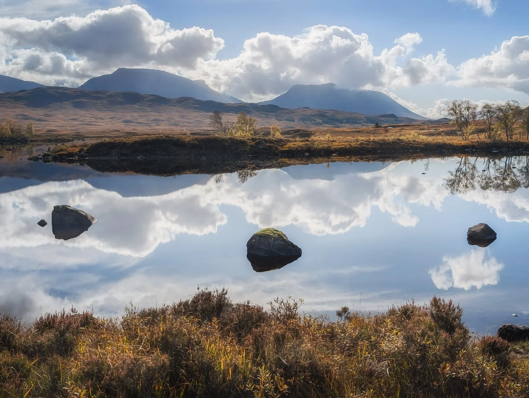  The western point of  Loch Bà  is easier to access. There&rsquo;s a small car park and a layby, where you can then clamber up a small mound to get expansive views of the loch and the moor. We continued beyond the mound to get as close to the loch shore as possible. Armed with waterproof boots and socks, we squelched tactically across the moorland to reach the loch shore, greeted by these incredible reflections. The two peaks here, left to right, are  Beinn a&rsquo; Chreachain  (1,081 m/3,547 ft) and  Beinn Achaladair  (1,038 m/3,406 ft). 