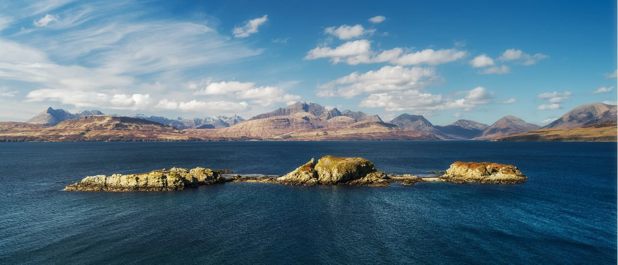  The view you can enjoy from Tokavaig&rsquo;s cliffs. The small trio of islands in the loch are called  Eilean Ruairidh , translating as &ldquo;Isle of the Red King&rdquo;. There was once a fort here too. From this view, it&rsquo;s clear to view the geological differences between the Black Cuillins, towards the left, and the Red Cuillins towards the right. The Red being smoother and made of granite, and the Black being more jagged and made of gabbro. 