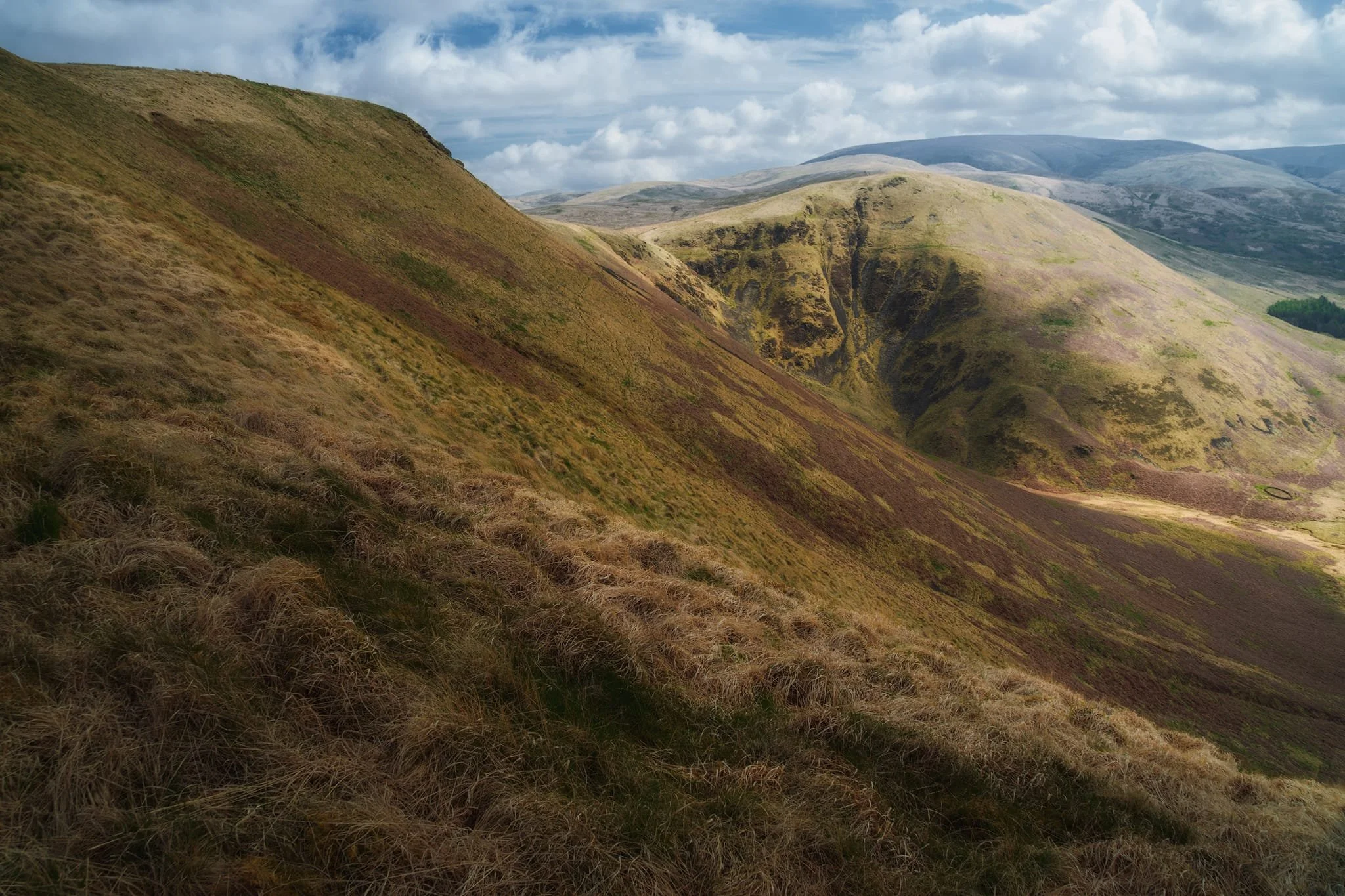  The following morning we woke up nice and early to return to the Devil&rsquo;s Beef Tub. From the layby you can take the Annandale Way up onto Annanhead Hill and continue on as far as you want across the peaks of the Southern Uplands. Part way up Annandale Hill we steered off the path to get close to the edge of the tub, presenting this sheer drop down and view towards the steep western face of Great Hill. 