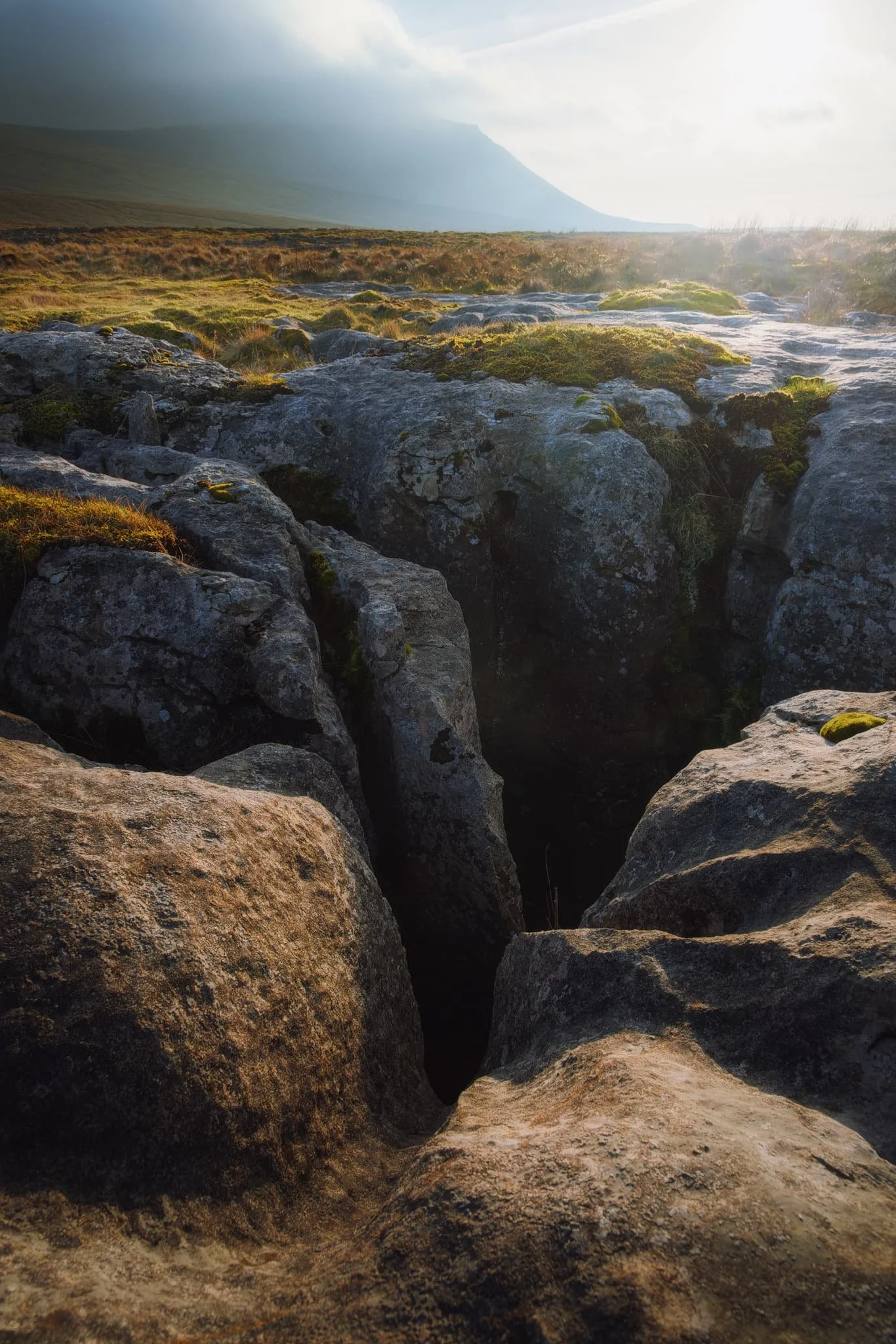  The last deep grike I could find, with more of Ingleborough&rsquo;s unmistakeable shape being revealed from the clouds. Give it several thousands of years and these grikes will become new potholes down into the caves. 