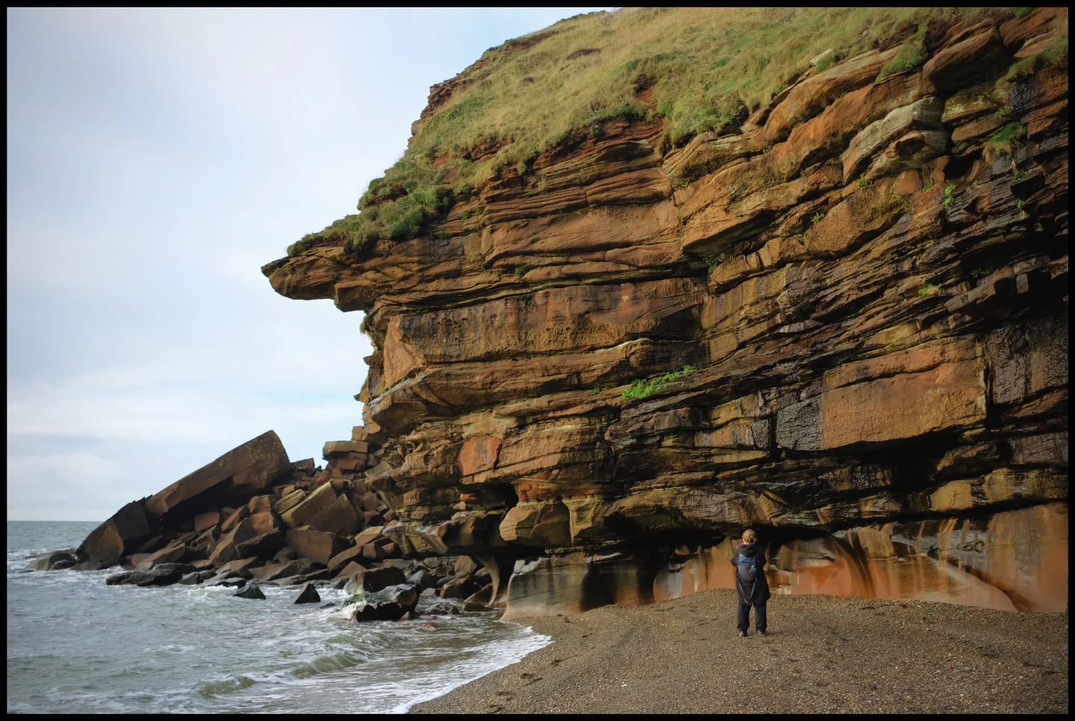  My lovely Lisabet, providing a sense of scale against the deep red jenga-like cliffs of Fleswick Bay. 
