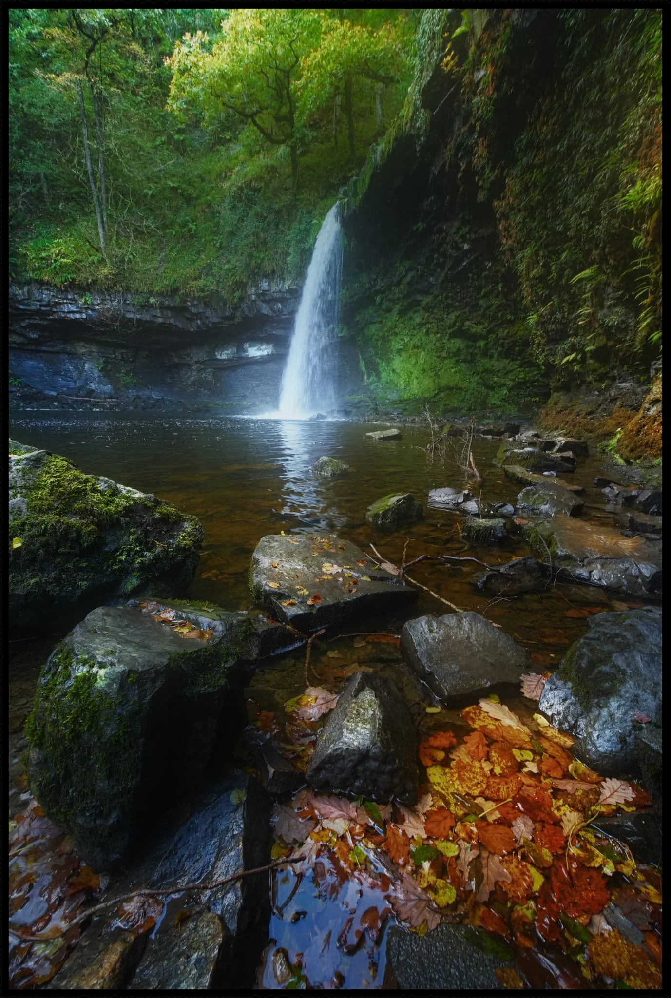  We gingerly navigated the slippery and mossy boulders to get as close to the falls as possible whilst the light shining down into the gorge was still complementary. Rusty autumn leaves provide colour contrast in the foreground. 