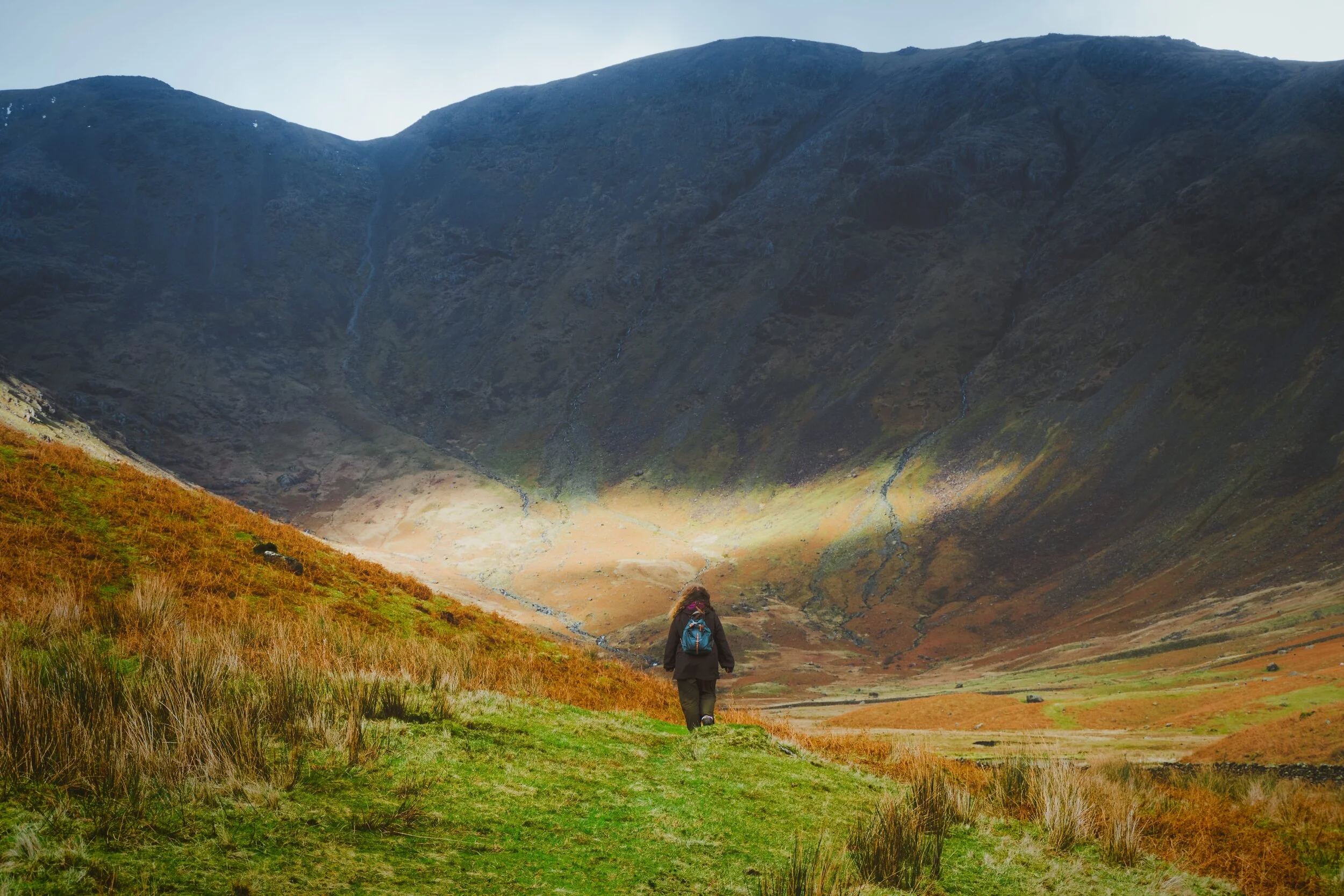  My wonderful Lisabet, looking tiny in the face of Pillar&rsquo;s (892 m/2,927 ft) sheer southern wall. A small band of light escaped from the clouds behind us to hit the wall. 