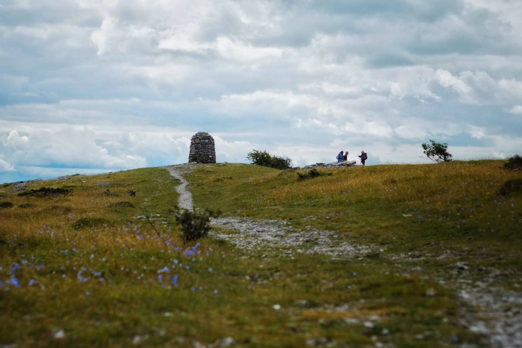  Approaching the wind-blasted summit and cairn of Lord&rsquo;s Seat, which also serves as a signal to take a rest for water and a snack. 
