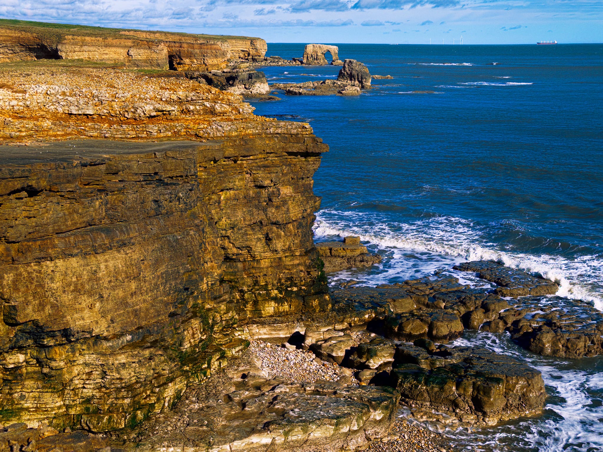 A tighter zoom along the cliffs and what&rsquo;s that? A sea arch! Amazing. Always a delight to see one of those.