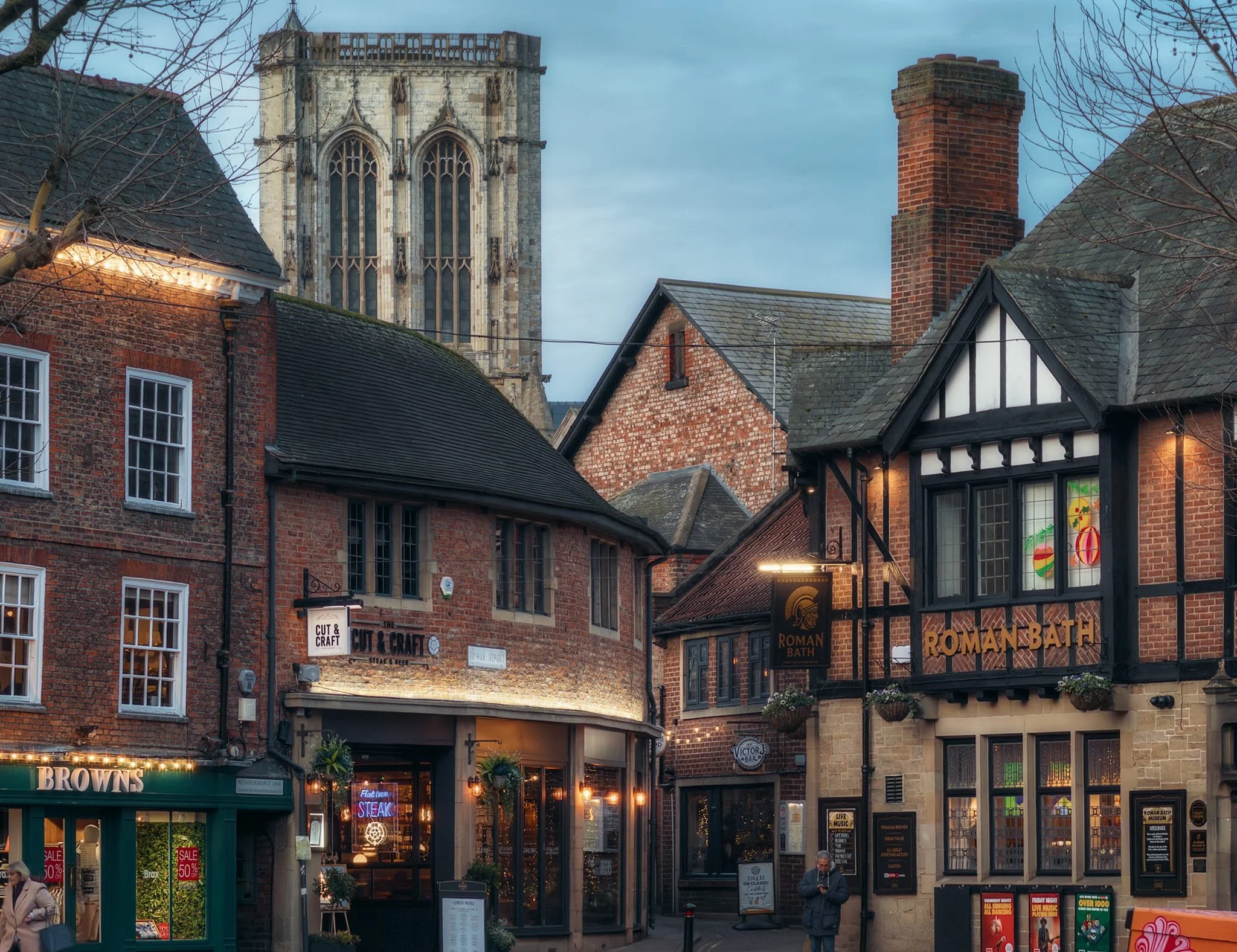  A quiet evening moment in St. Sampson&rsquo;s Square, looking towards Finkle Street and the Minster. St. Sampson&rsquo;s Square was historically a main retail space and a market was held here each Thursday. The Roman Bath Pub actually has a small Roman museum in its basement. 